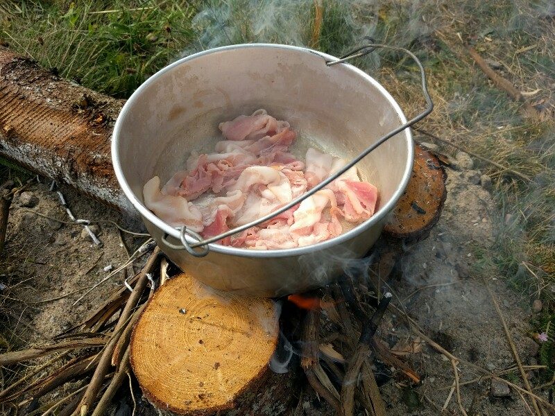Bacon som håller på att stekas över ene-elden.